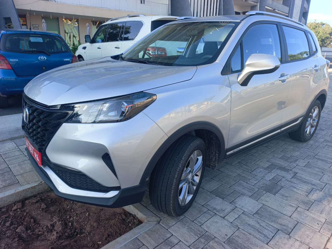 Changan CS15 gris trois-quarts avant devant un immeuble